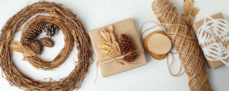 Eco-friendly Christmas decor: gift boxes Packed in brown Kraft paper, natural decorations, wreath, pine on white background. Zero Waste holiday packing concept, handmade gifts package, 2022 New yearの写真素材