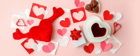 Flat lay of heart shaped cup of black coffee, gift box and candy on pink background with copy space. Valentine's day, beverage concept, Good morning, romance surprise, banner, flyerの写真素材