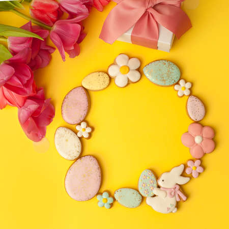Sweets, pastry, gingerbread cookies for Easter table. Easter eggs, rabbit and tender simple flowers...