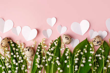 Spring Easter holiday pink background with wild may-lily, quail eggs, paper hearts. Banner for your...