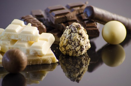 Chocolate assortment on a black background with reflectionの写真素材