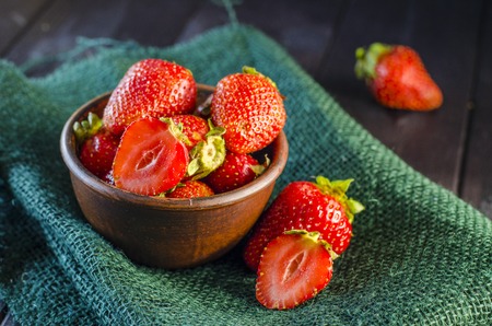 Ripe strawberry in a bowl on a close-up table