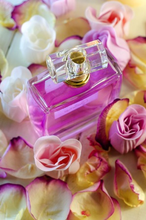 Perfume bottle with pink roses petals. Fashion makeup and body care products.の写真素材