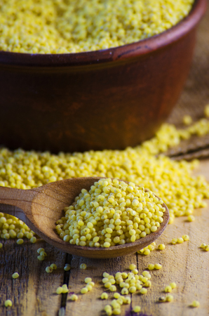 Raw millet in a bowl on a tableの写真素材