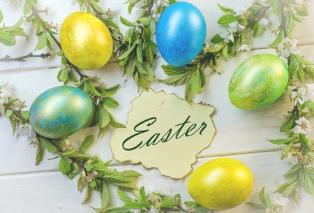 festive colored Easter eggs on a cherry blossom backgroundの写真素材