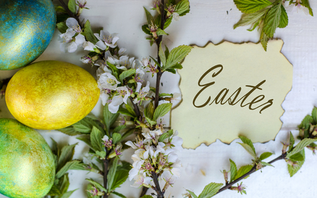 festive colored Easter eggs on a cherry blossom backgroundの写真素材