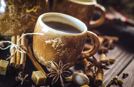Tasty hot coffee with grains and spices on tableの写真素材
