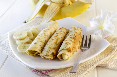 pancakes with cottage cheese and a banana on a white plateの写真素材