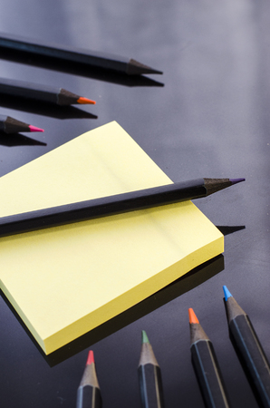 colored pencils and paper on a black background closeの写真素材