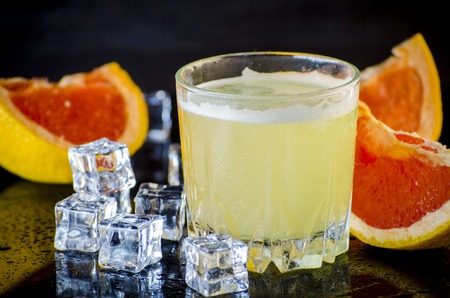 grapefruit drink with ice on a black backgroundの写真素材