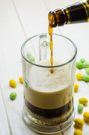 dark beer pouring into a glass bottle