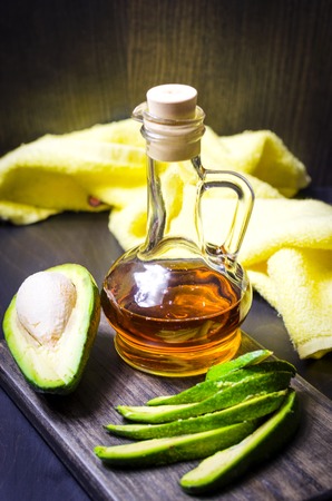 fresh avocado and oil from it on the tableの写真素材