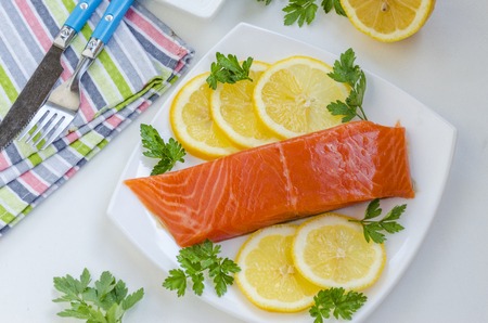 piece of raw salmon on a plate with lemonの写真素材