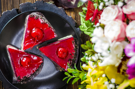 birthday cake with cherry on a background of flowersの写真素材