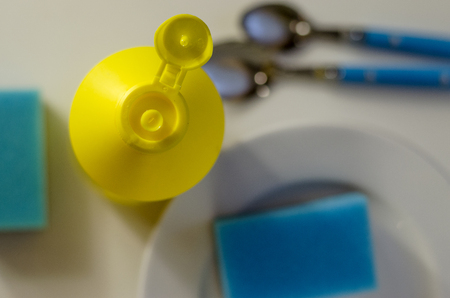 Bottle of dishwashing liquid and stack of utensils isolated on whiteの写真素材