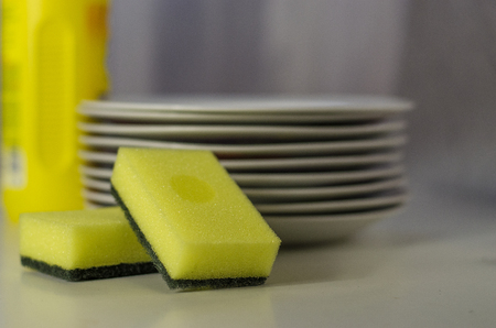 Bottle of dishwashing liquid and stack of utensils isolated on whiteの写真素材