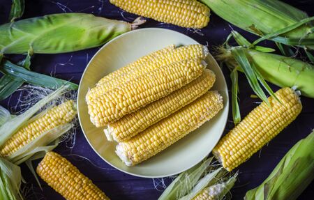 bobbed young corn partially peeled on the table