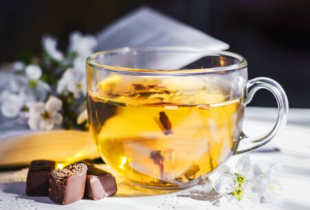 Tea in a cup and cherry flowersの写真素材