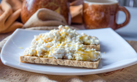 Breakfast of diet bread with cottage cheese and honeyの写真素材