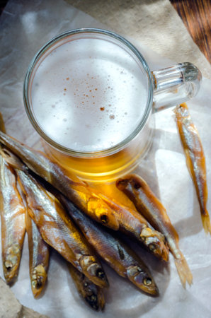 Light beer in a glass beer mug and smoked fishの写真素材
