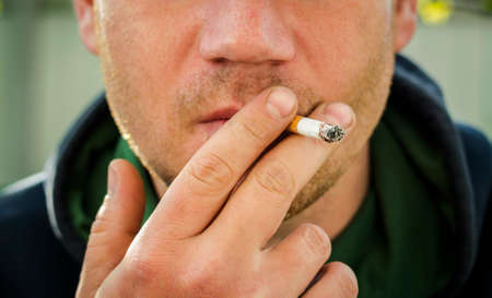 Man with cigarette in hand, smoker close up.の写真素材