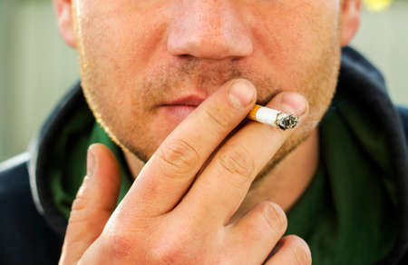 Man with cigarette in hand, smoker close up.の写真素材