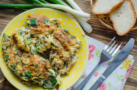 Egg omelet with fresh greens and onions in a bowlの写真素材
