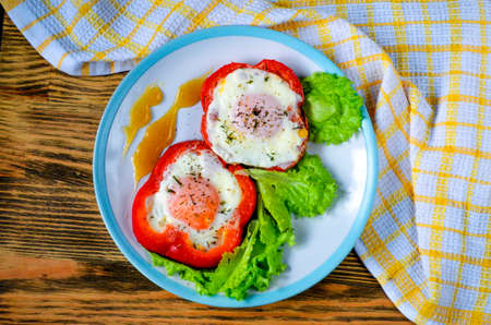 Fried chicken eggs in bell pepper. Breakfast on a plate.の写真素材