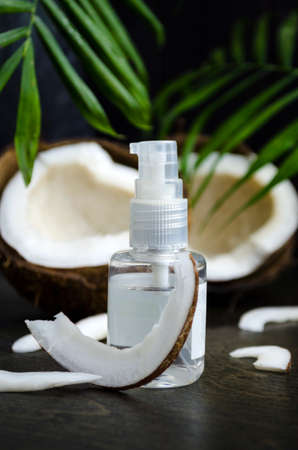 Coconut oil for hair in a bottle with a dispenser on a dark backgroundの写真素材