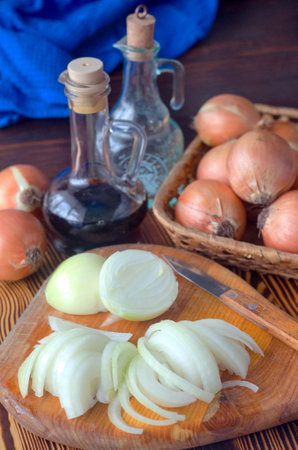 Onions cut into half rings on a kitchen board. Pieces of fresh onions.の写真素材