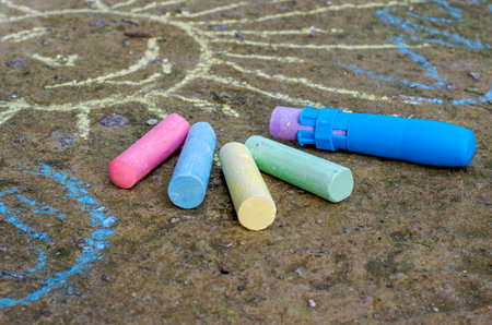 Children's multi-colored chalk and chalk holder on the asphalt. painting and drawings on the sidewalk.の写真素材