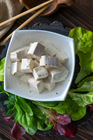 Fresh vegan product - tofu. Soy gray tofu on a plate marinated with spices and salad leavesの写真素材