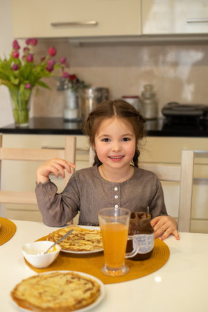 Cute little girl have a breakfast with pancake in maslenitsa timeの写真素材