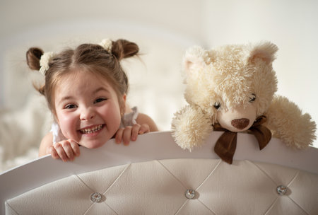 Happy little girl have a fun with teddy bearの写真素材