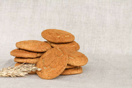 a stack of oatmeal cookies on a gray fabric linen background.