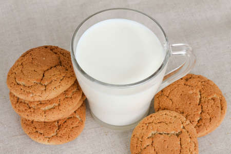 oatmeal cookies with a glass of milk on a linen background, top view, flat lay, text space.の写真素材