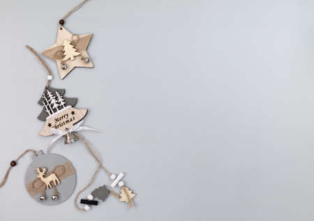 Wooden Christmas decorations on gray background leftward, top view, flat lay, copy space for textの写真素材