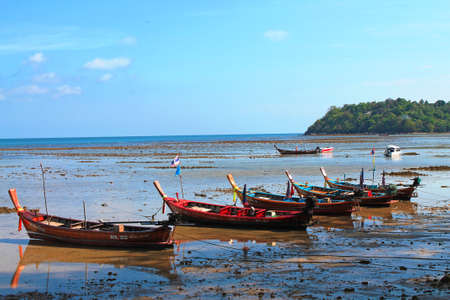 Rawai, Thailand- 02.03.2013: The wooden local traditional longtail fishing boats on sea beach in low tide time.のeditorial素材