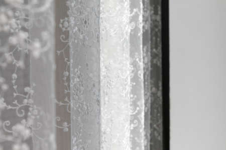 Blurry view of a transparent curtain close-up at the window. Focus in the background.の写真素材