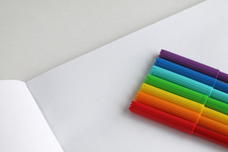 colorful markers are placed on a white sheet, rainbow, there is an empty space for the text next to itの写真素材