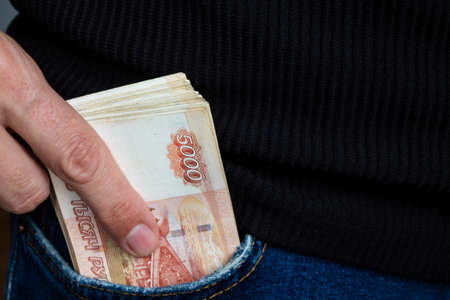 A wad of money sticks out of the pocket of jeans, Russian five-thousand-dollar bills.の写真素材