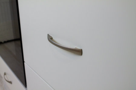 Handle for white kitchen cabinet. Furniture handle matte chrome. High quality photoの写真素材