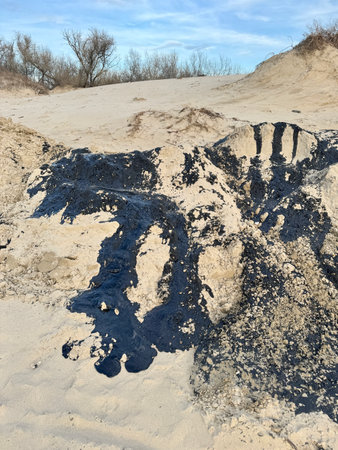 The beach is polluted with fuel oil. Consequences of the oil spill on the coast, environmental pollution, oil spill in the Black Sea, oil tanker wreck, environmental disasterの写真素材