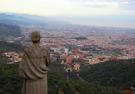 Barcelona, Catalonia, Spain - November 20, 2021: Panoramic view of the city of Barcelona with a religious statue from the Temple of the Sacred Heart on Tibidabo Hillのeditorial素材