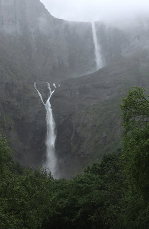Vertical photo with a view of the Mardalsfossen waterfall cascade in light mist during rain near Andalsnes in Norwayの写真素材