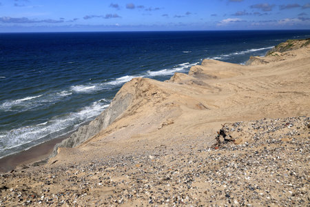 Landscape photo with a view of the North Sea coast and sand dunes against a blue sky with clouds near the Rubjerg Knude lighthouse in Denmarkの写真素材