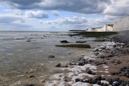 Landscape photo with a view of the chalk cliffs of the Seven Sisters illuminated by the sun and the...