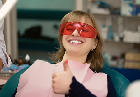the client at the dentists office in the office smiles