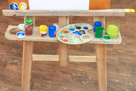 the artist's instruments on the easel are close-ups. paints, brushes