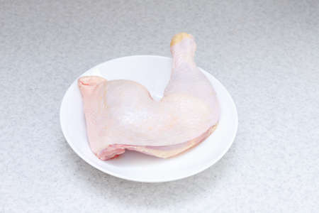 chicken leg on a white plate on the tableの写真素材